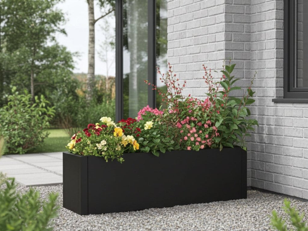 Sort plantekasse i stål med farverige blomster ved moderne hus