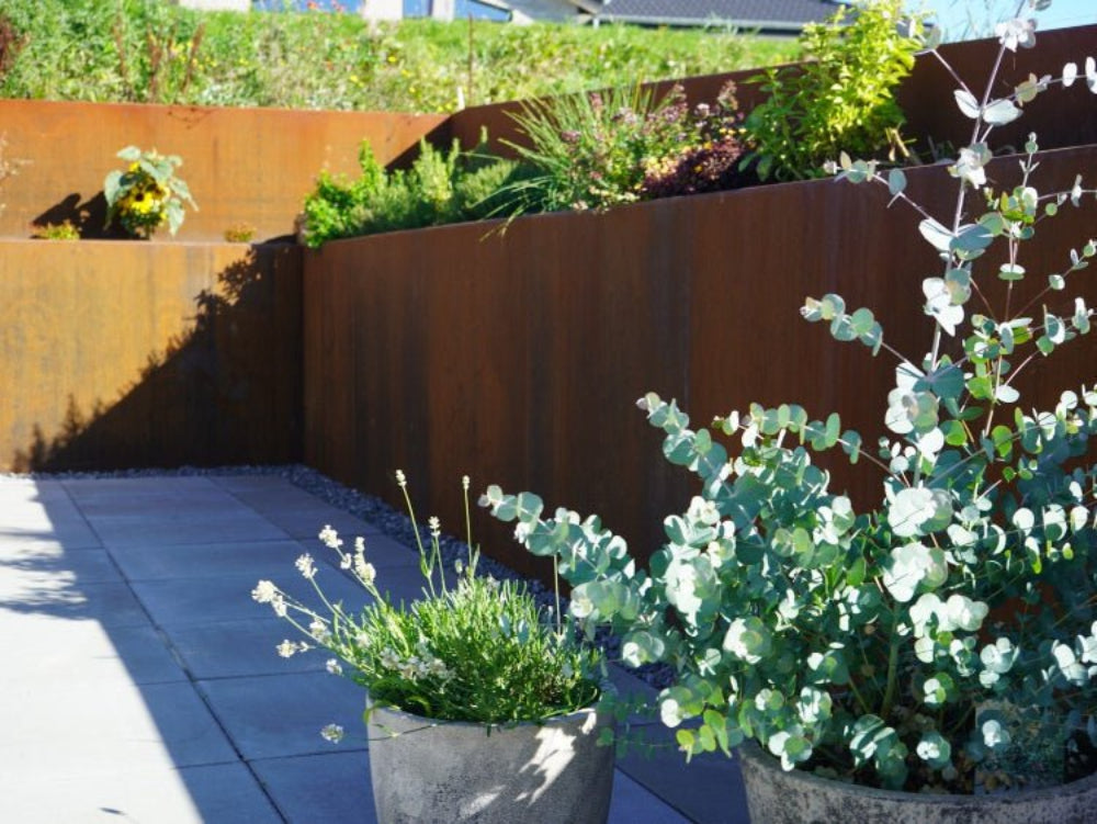 Støttemur i cortenstål omkring plantebed ved terrasse