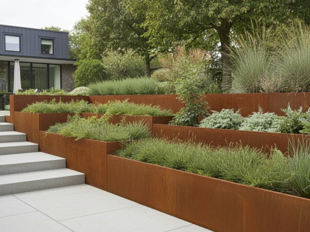 Terrasseret støttemur i cortenstål med stauder og prydgræsser ved trappe i have